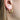 Gold plated hoop earring with small cubic zirconia worn by a person