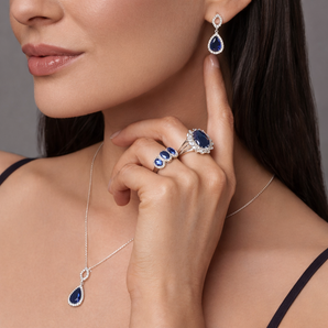 Urban Pizazz Model Wearing Matching Sterling Silver Sapphire CZ Jewellery, Including 2 Rings, a Necklace and Matching Earrings