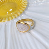 Gold plated ring with white liquid enamel on a white and yellow plate