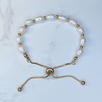 Embrace timeless coastal elegance with our Beach Pearl Bolo Bracelet. Featuring freshwater pearls delicately spaced with polished gold-toned beads, the adjustable bolo clasp ensures a comfortable fit for any wrist. Shop now for quality Jewellery/Jewelry!