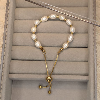 Embrace timeless coastal elegance with our Beach Pearl Bolo Bracelet. Featuring freshwater pearls delicately spaced with polished gold-toned beads, the adjustable bolo clasp ensures a comfortable fit for any wrist. Shop now for quality Jewellery/Jewelry!