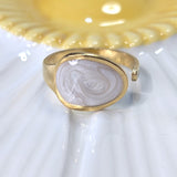 Gold plated ring with white liquid enamel on a white and yellow plate