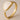 Adjustable gold plated ring with a white liquid enamel on a beige background