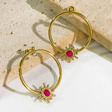 Harper Starburst gold  plated hoop earrings with pink gemstones on a textured surface