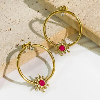 Harper Starburst gold  plated hoop earrings with pink gemstones on a textured surface