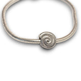 Sterling silver nautilus shell bead charm symbolising growth and renewal. Hypoallergenic, fits most charm bracelets - elegant and meaningful jewellery.
