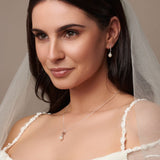 Urban Pizazz Model Wearing Sterling Silver Pearl Pendant With Cubic Zirconia Details and matching pearl earrings