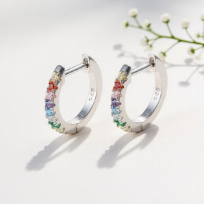 10mm Rainbow Huggie Hoop Earrings – 925 Silver & CZ by Urban Pizazz. Shop 10mm rainbow huggie hoops in 925 sterling silver. Colorful cubic zirconia stones, dainty, hypoallergenic, and perfect for everyday sparkle.