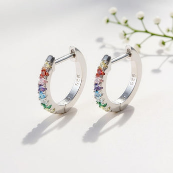 10mm Rainbow Huggie Hoop Earrings – 925 Silver & CZ by Urban Pizazz. Shop 10mm rainbow huggie hoops in 925 sterling silver. Colorful cubic zirconia stones, dainty, hypoallergenic, and perfect for everyday sparkle.