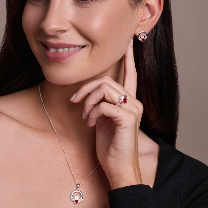Urban Pizazz model wearing sterling silver claddagh jewellry featuring garnet red cubic zirconia heart centre stones
