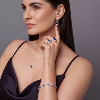Urban Pizazz Model Wearing Luxury Sapphire Cubic Zirconia Bracelet and Matching Sapphire CZ Necklace Earrings Rings